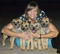Team member Manuela with a group of four puppies